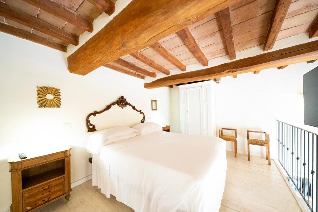 佩鲁贾乐斯坦斯迪伽利略酒店的卧室设有白色的床和木制天花板。