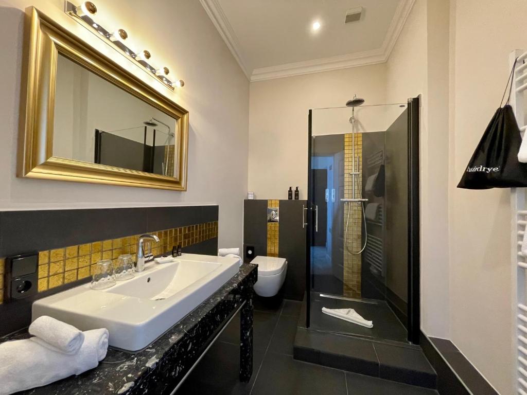 奥斯赛拜-屈隆斯博恩meergut HOTELS的一间带水槽、淋浴和卫生间的浴室
