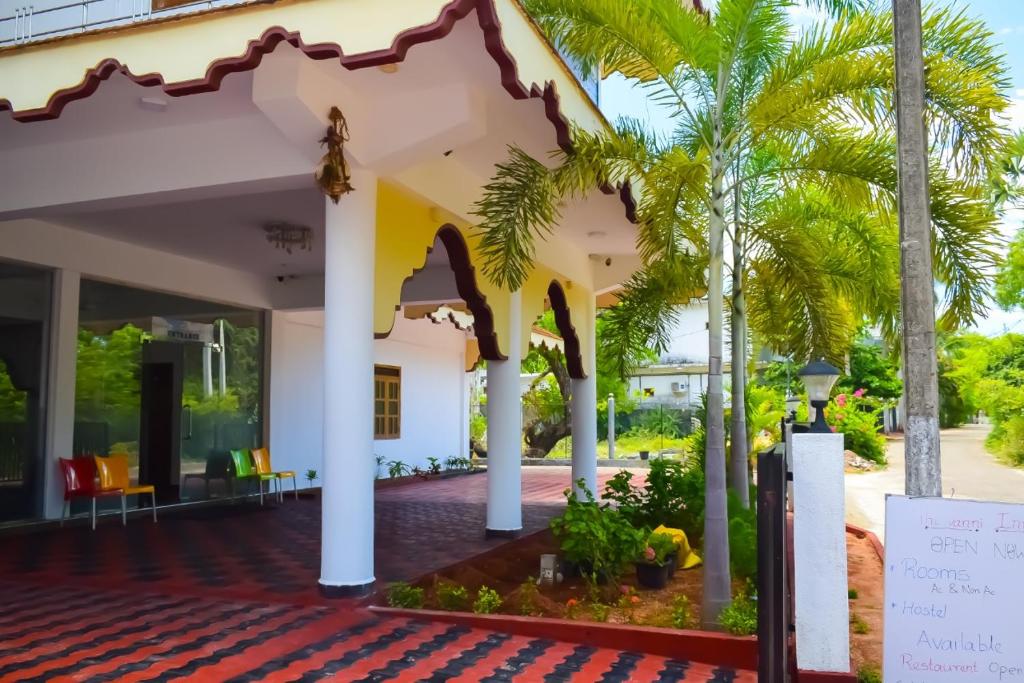 亭可马里Hotel Theevanni Inn的享有棕榈树房屋前门廊的景致