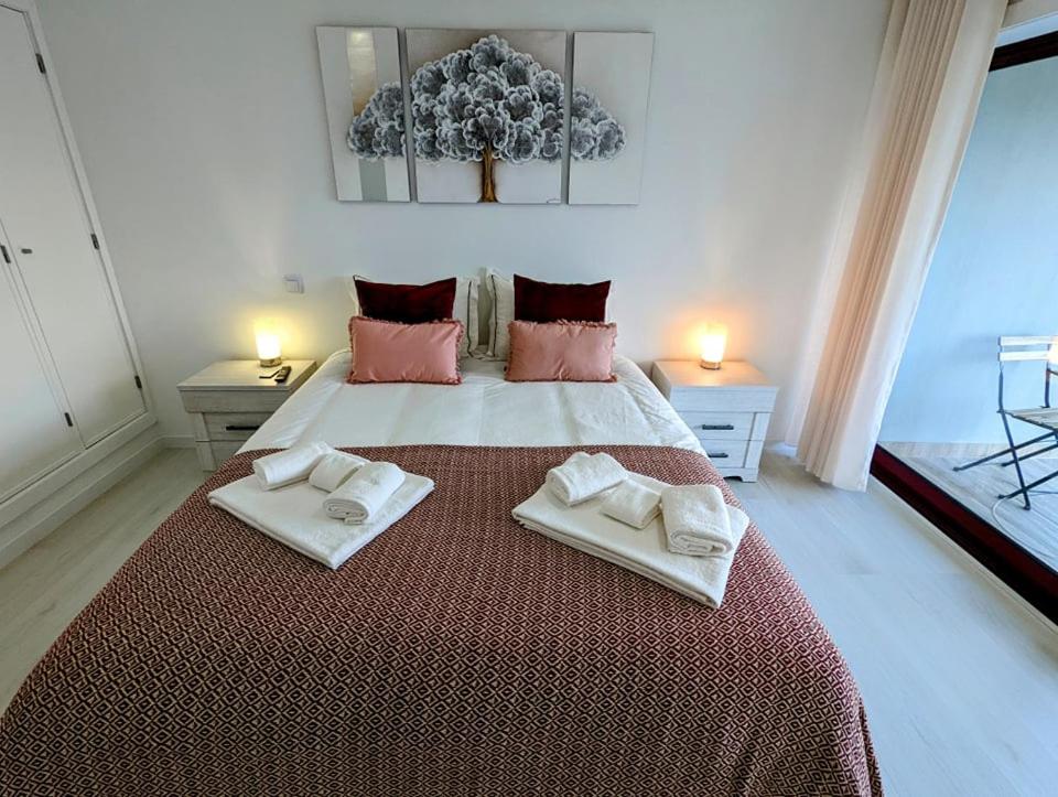 普拉亚达巴拉Silvaapartments的一间卧室配有一张大床和两条毛巾