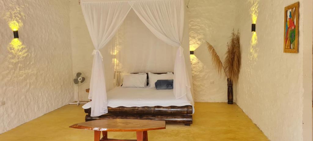 莫科阿Posada Turistica Dantayaco的一间卧室配有一张带桌子的天蓬床