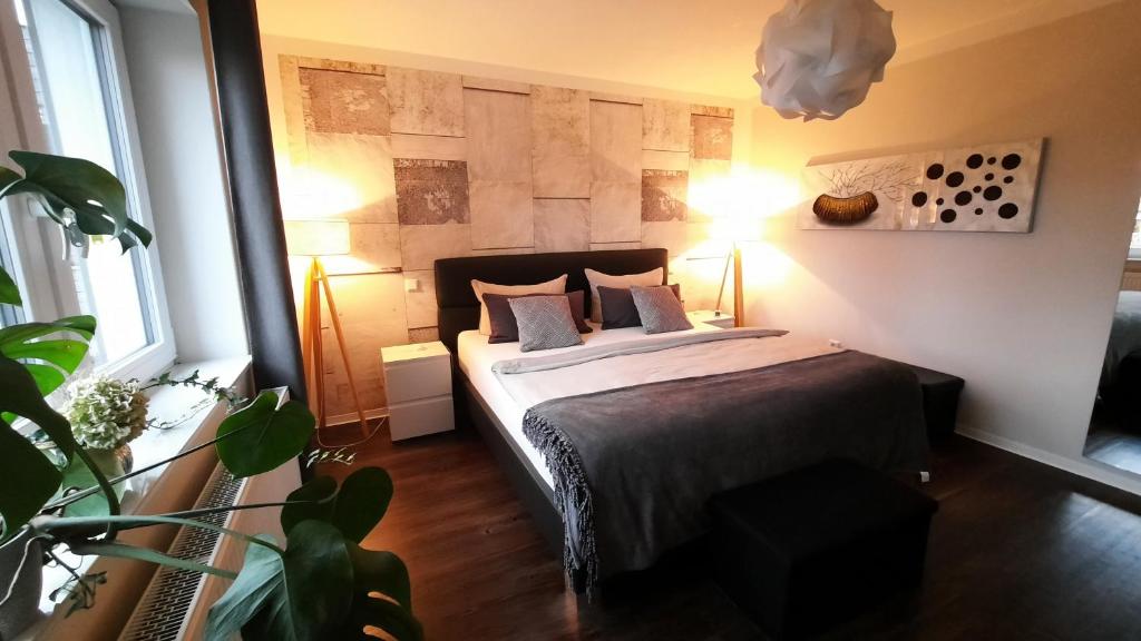 卡塞尔Appartment Fasanenhof Klinikum und Uni nah mit Netflix的一间卧室,配有一张带两盏灯和一根植物的床