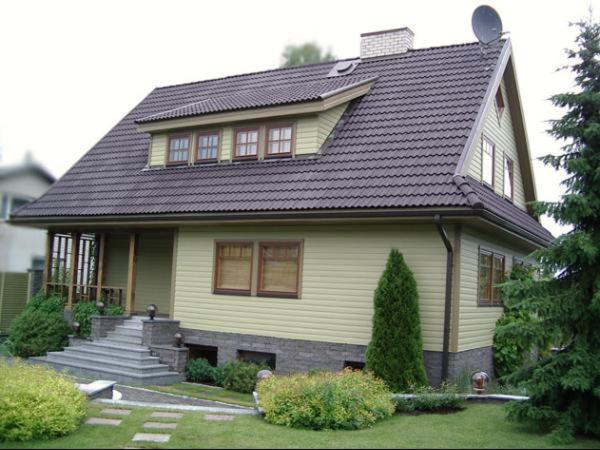 奥泰佩Tammehouse的黑色屋顶的黄色房子