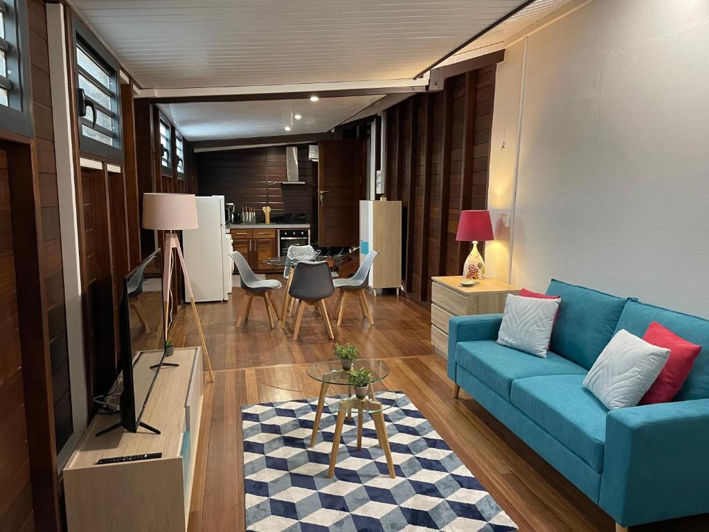 库鲁CHARMANT T2的一间带蓝色沙发的客厅和一间厨房