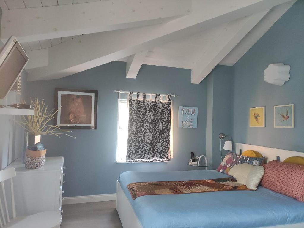 伊莫拉Ca' Moni - Imola的一间卧室配有一张蓝色墙壁的床和一扇窗户