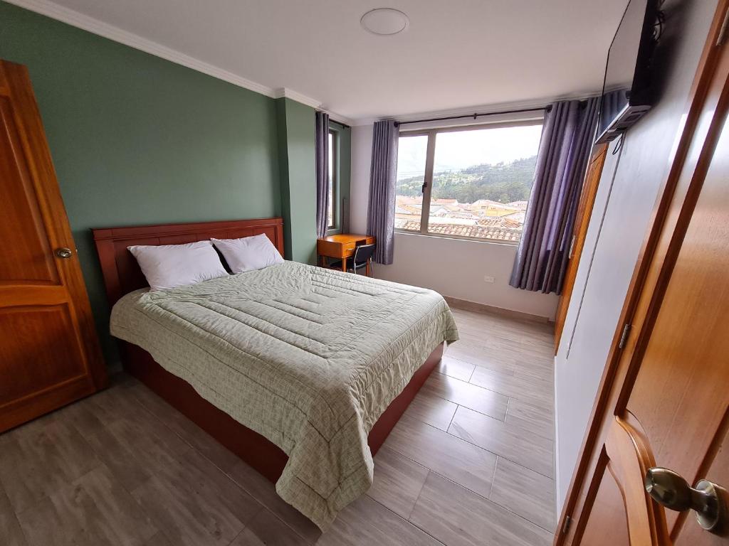 昆卡Hostal Morlaquita的一间卧室设有一张床和一个窗口