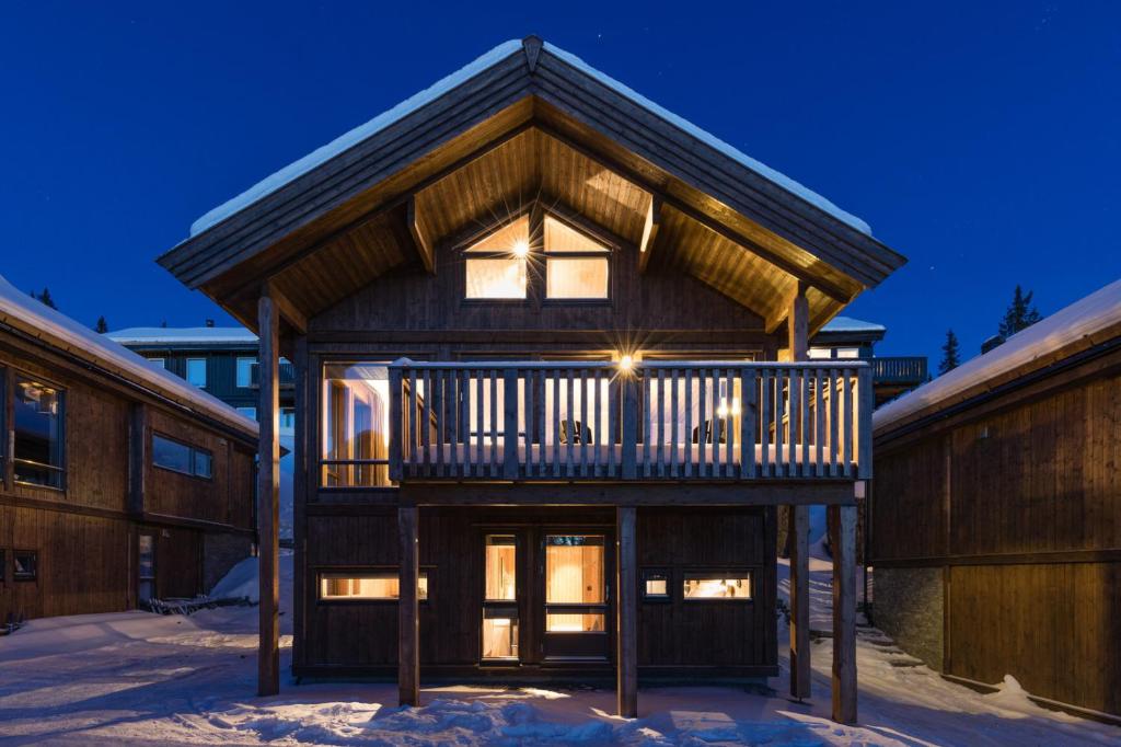 奥耶Cozy modern holiday villa with electric car charging, sauna and fireplace的木屋的顶部设有阳台