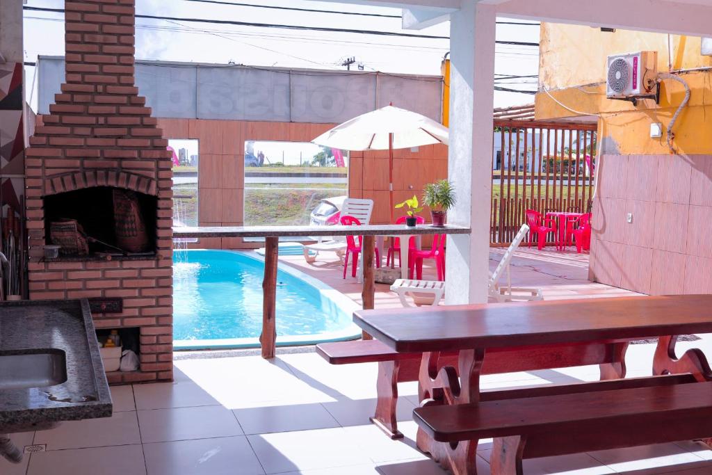 伊列乌斯Pousada e Restaurante Palomar的庭院设有游泳池、桌子和壁炉