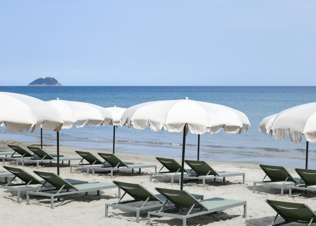 莱圭利亚Hotel Windsor的海滩上的一组椅子和遮阳伞