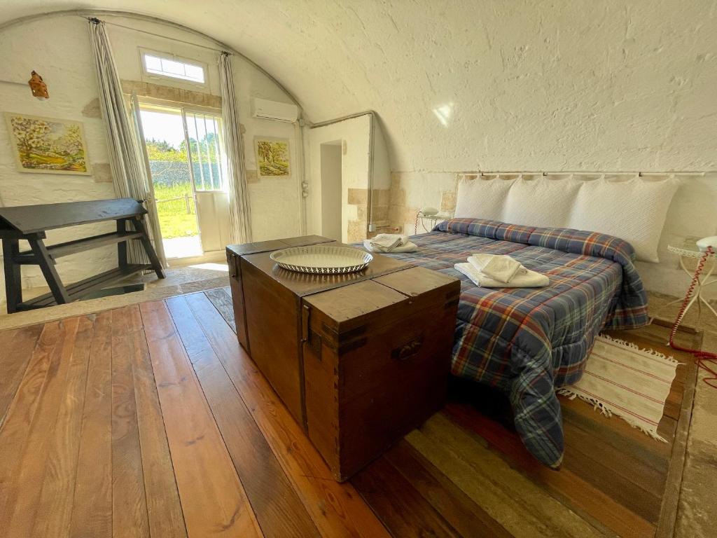 穆罗莱切塞Tenuta Sant'Andrea的一间卧室配有一张带桌子和窗户的床