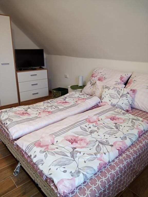 鲍洛通凯赖斯图尔常春藤公寓的一张床上有粉红色花朵的睡床