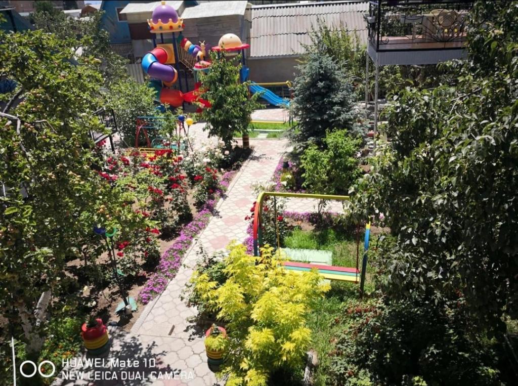 乔尔蓬阿塔Гостевой дом Асель的享有花园的顶部景致,设有游乐场