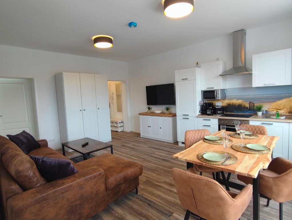 科瑟罗Villa Boberg Apartments的厨房以及带桌子和沙发的客厅。