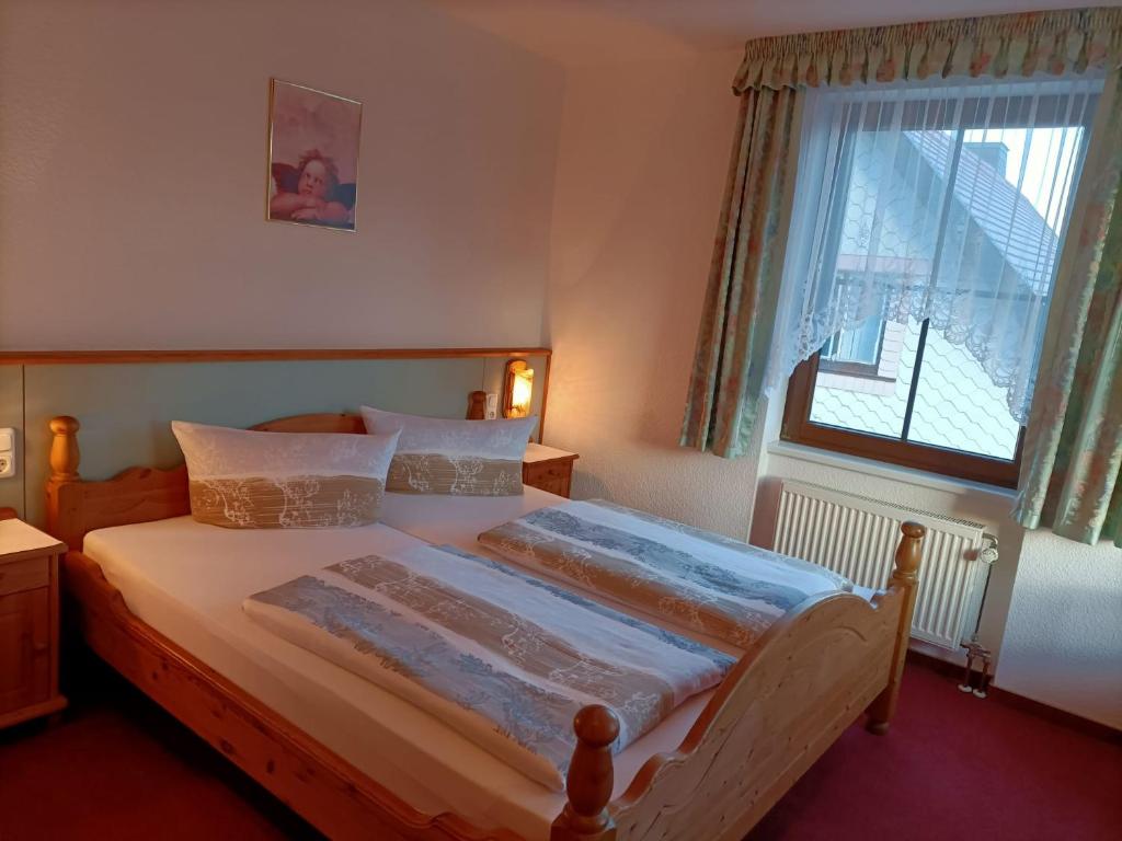 施尔奇Pension Drei Elstern的一间卧室设有一张大床和窗户