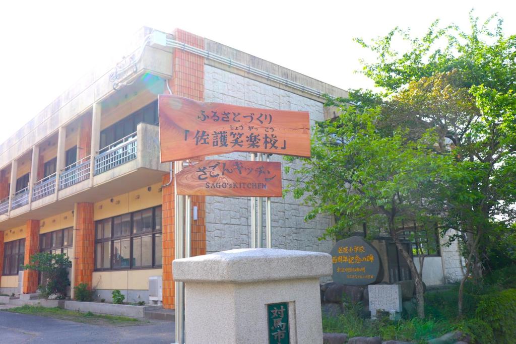 对马市Guest House「さごんヴィレッジ」的建筑物前的街道标志