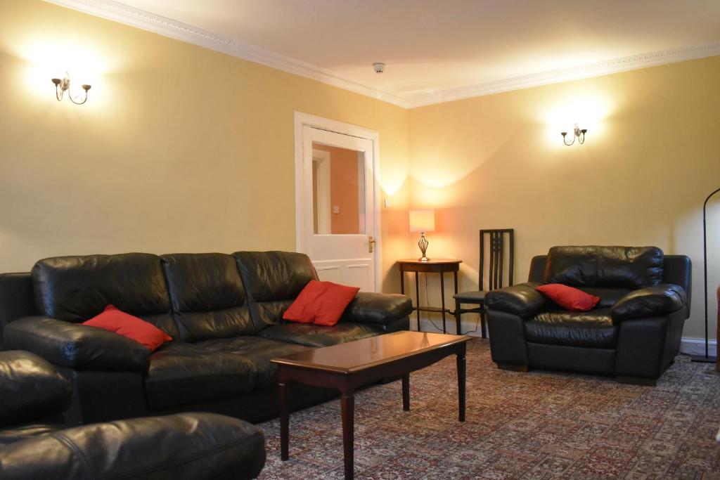 爱丁堡West End Apartment的客厅配有真皮沙发和桌子