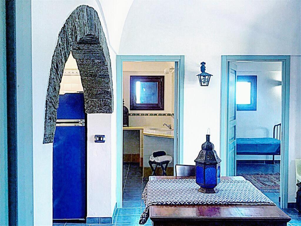 潘泰莱里亚dammuso dehors的客厅设有蓝色的门和桌子