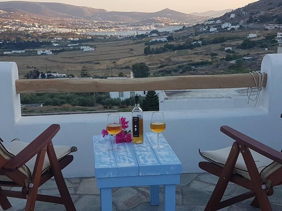 KrotiriEvilou's House的一张桌子,上面放有两杯葡萄酒和一瓶
