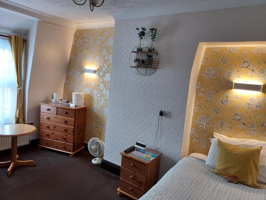 大雅茅斯马璐斯旅馆的一间卧室配有一张床、梳妆台和桌子
