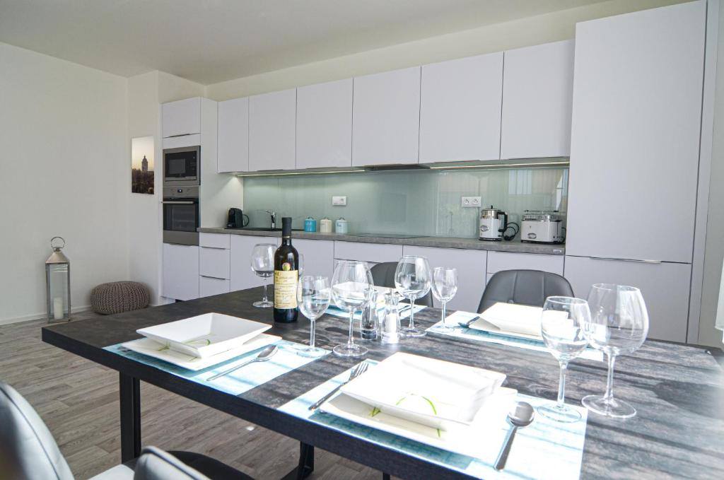 米库洛夫Palm Garden Apartment 1的餐桌,配有一瓶葡萄酒和玻璃杯
