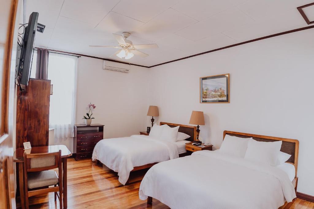 圣何塞邓恩酒店的一间卧室配有两张床和吊扇