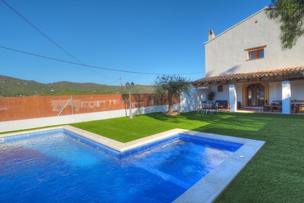 圣佩德罗-德里瓦斯Villa Can Roig by Hello Homes Sitges的一座房子旁的院子内的游泳池