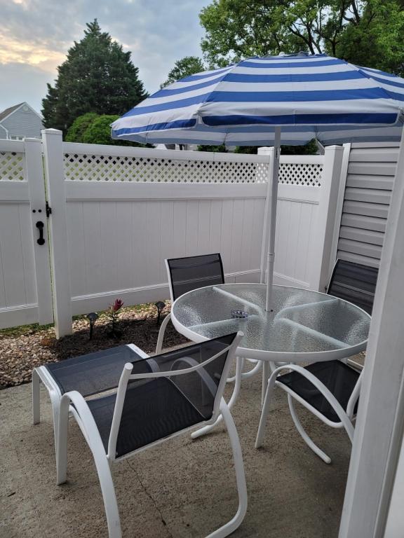罗利Heart of Raleigh的庭院里配有桌椅和遮阳伞