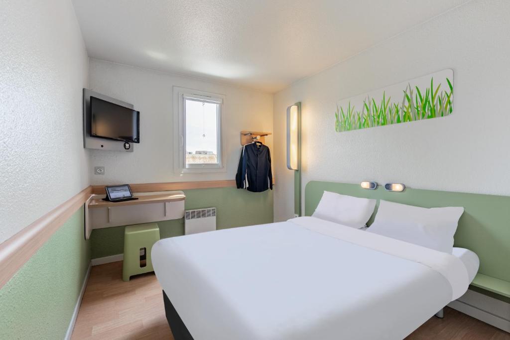 希尔蒂盖姆B&B HOTEL Strasbourg Nord Schiltigheim的酒店客房设有一张大床和一台电视机。