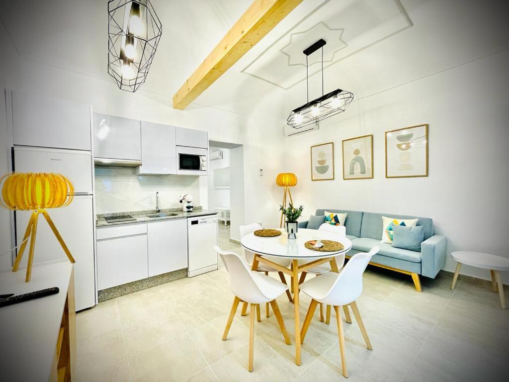 梅里达Apartamentos Guaditania的厨房以及带桌椅的起居室。