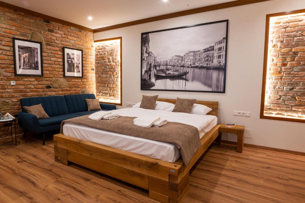 旧柳博夫尼亚Penzión Kolkáreň的一间卧室配有一张大床和一张蓝色的沙发