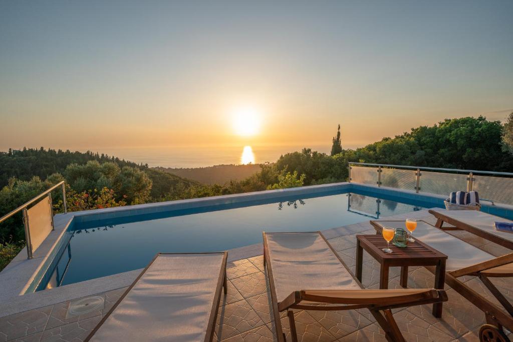 费斯卡尔德宏Stone Villa Eriphyle ,private witn sunset view的一个带桌椅的游泳池,享有日落美景