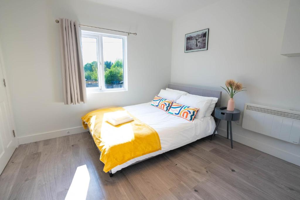 BuckinghamshireNo 02 Studio Flat Available near Aylesbury Town Station的一间卧室配有一张带黄色毯子和窗户的床