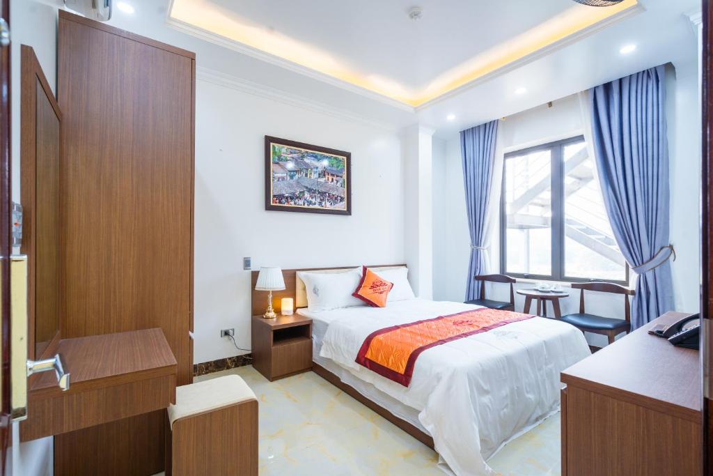 河江Đinh Gia Hotel的配有一张床、一张书桌和一扇窗户的酒店客房