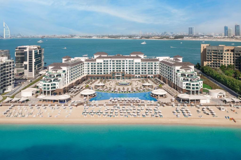 迪拜Taj Exotica Resort & Spa, The Palm, Dubai的享有带椅子和遮阳伞的度假村的空中景致