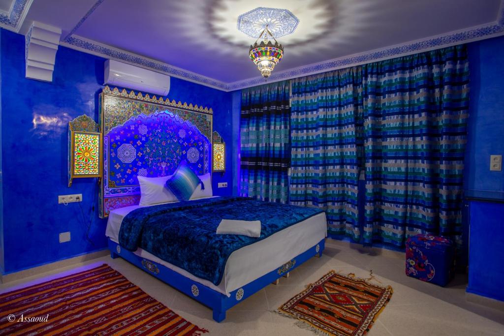 舍夫沙万阿苏尔普尔塔住宿加早餐旅馆的一间蓝色卧室,配有一张床和一个吊灯