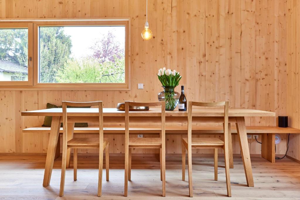 巴特科尔格鲁布Alpinlife Ferienhaus的木餐桌,椅子和花瓶