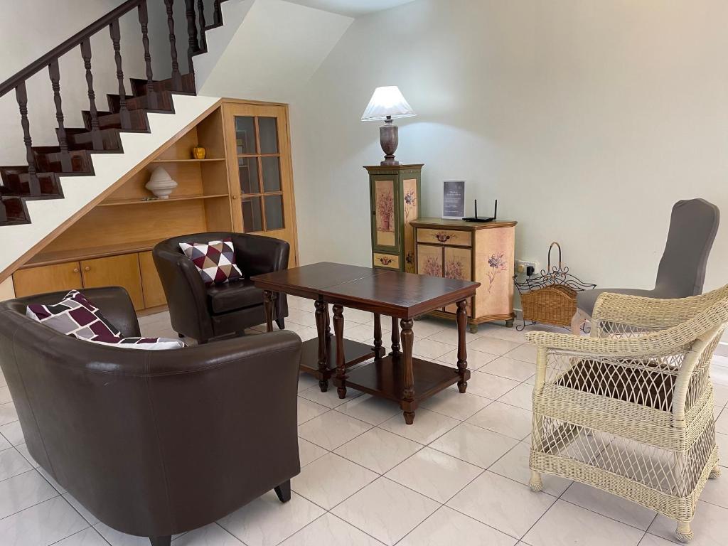 哥打京那巴鲁JML Family Homestay ~ Entire Residential Home的客厅配有桌椅和楼梯。