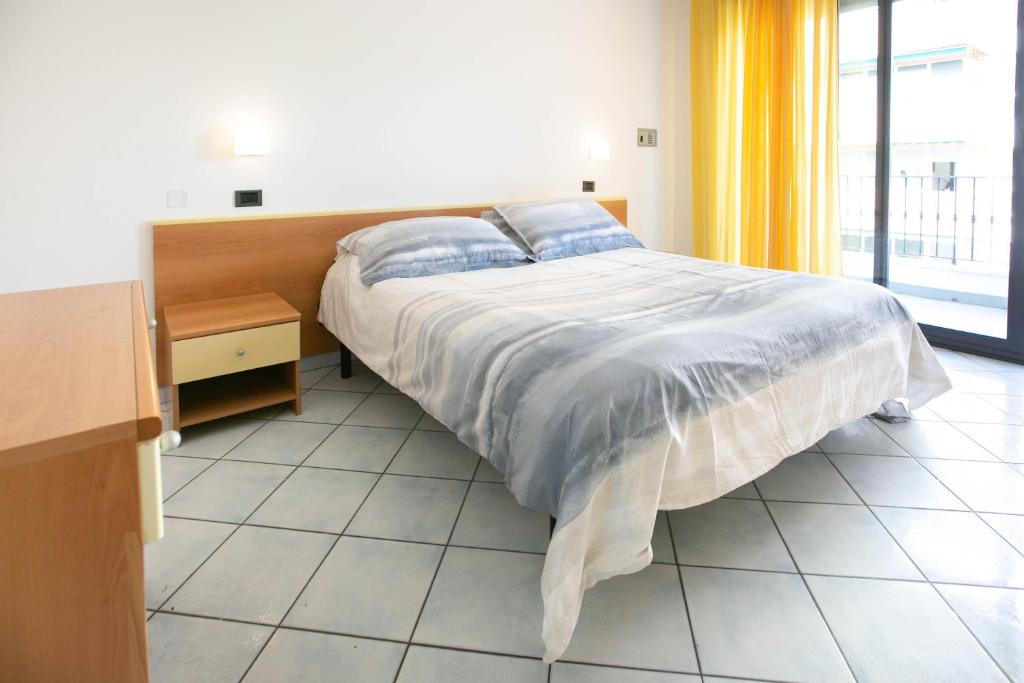 里米尼Residence Villa Dei Pini的一间卧室设有一张床和一个大窗户