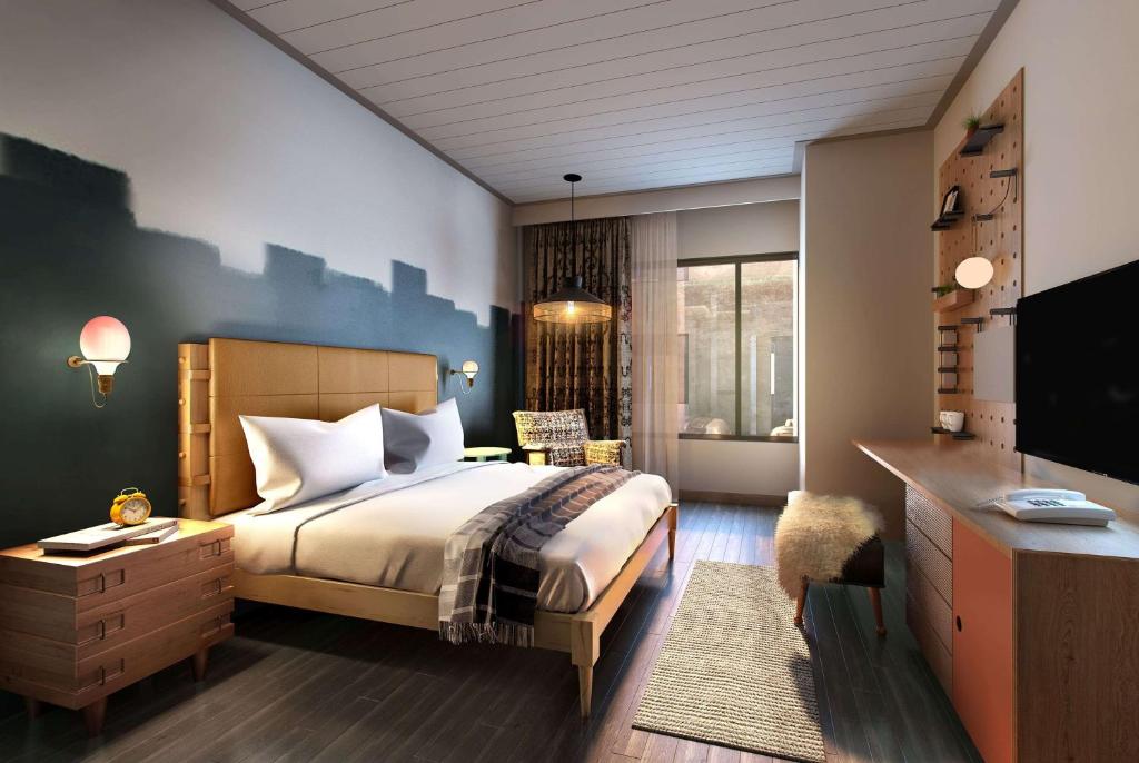 奥斯汀Origin Austin, a Wyndham Hotel的一间卧室配有一张床、一张书桌和一台电视