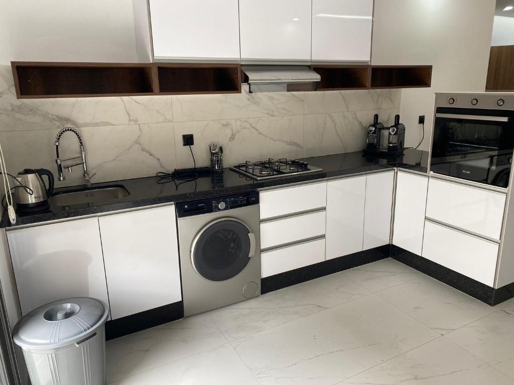 纳祖尔Iquama atawhid I的厨房配有白色橱柜和洗衣机。