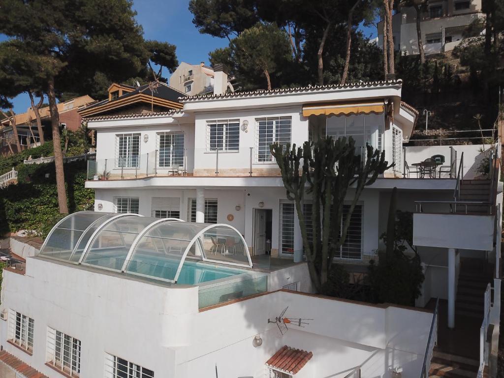 马拉加LU&CIA Villa Infinity的一座白色的房子,前面设有一个游泳池