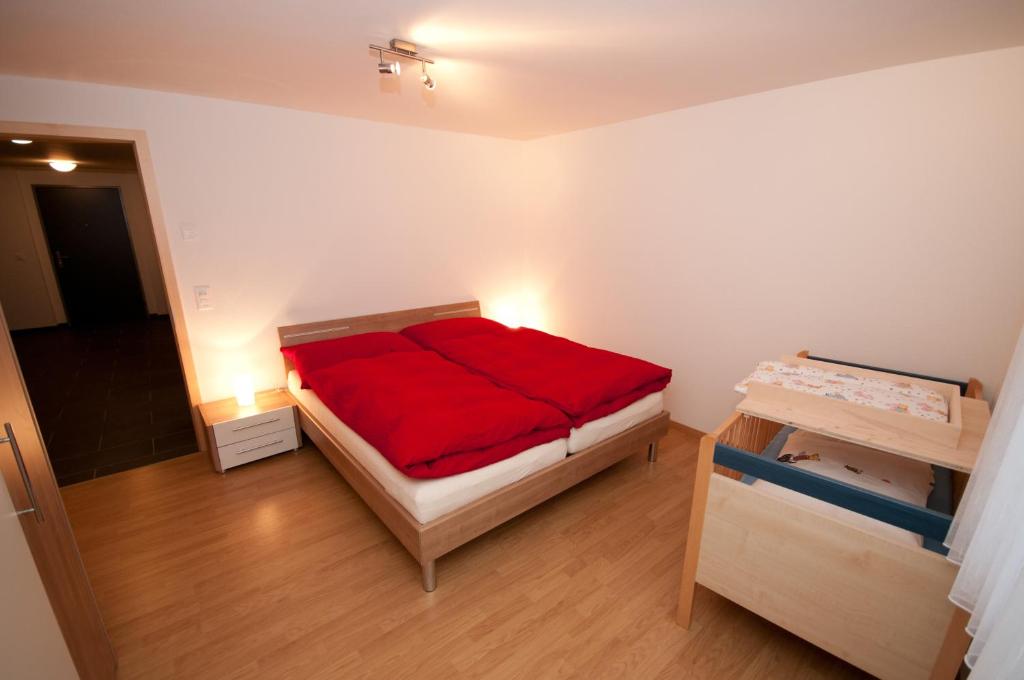 迈林根迈林根阿尔贝巴赫街4号公寓的一间设有一张红色毯子的床的房间