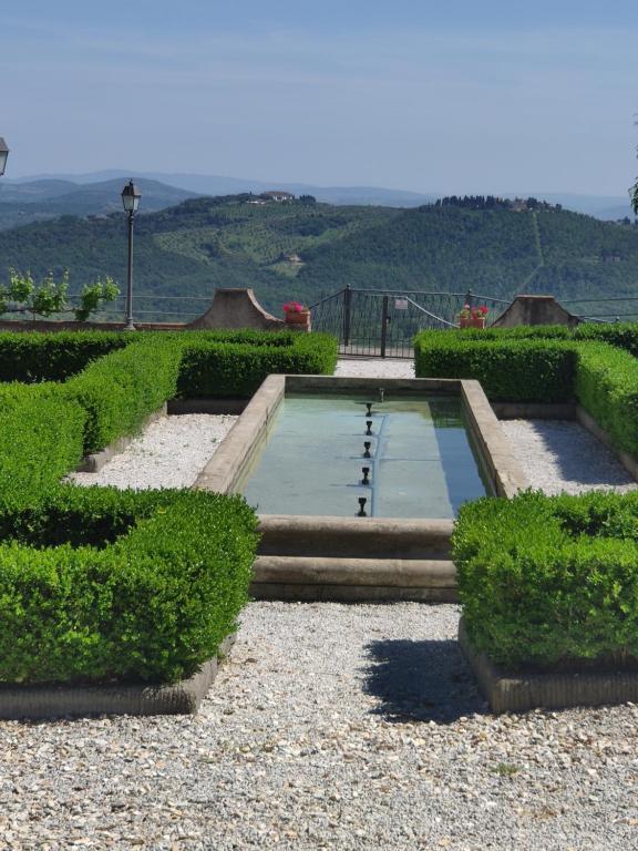 卡尔米尼亚诺Dépendance in Villa Albachiara e Primaluce的花园中的一个游泳池