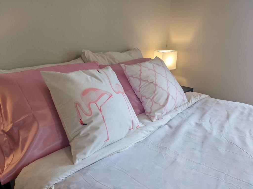 沃尔夫维尔Pink Flamingo的床上配有粉色和白色枕头的床