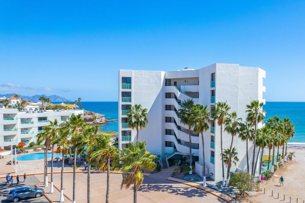 圣卡洛斯Condominios San Carlos的享有酒店和棕榈树海滩的景色