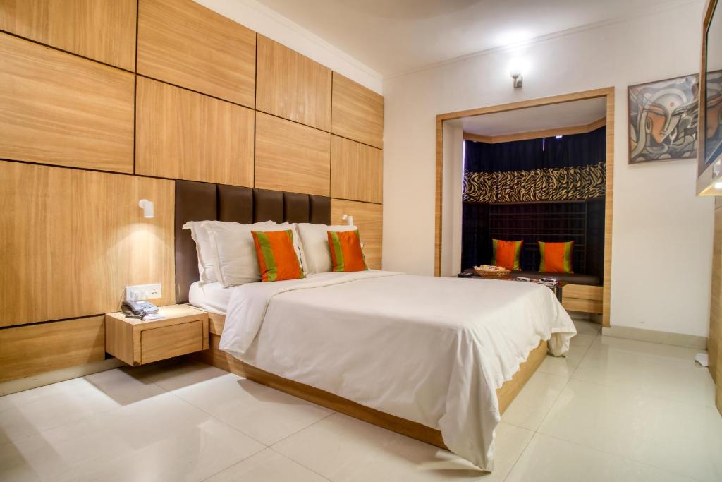 加尔各答罗兰德酒店的卧室设有一张白色大床和一扇窗户。