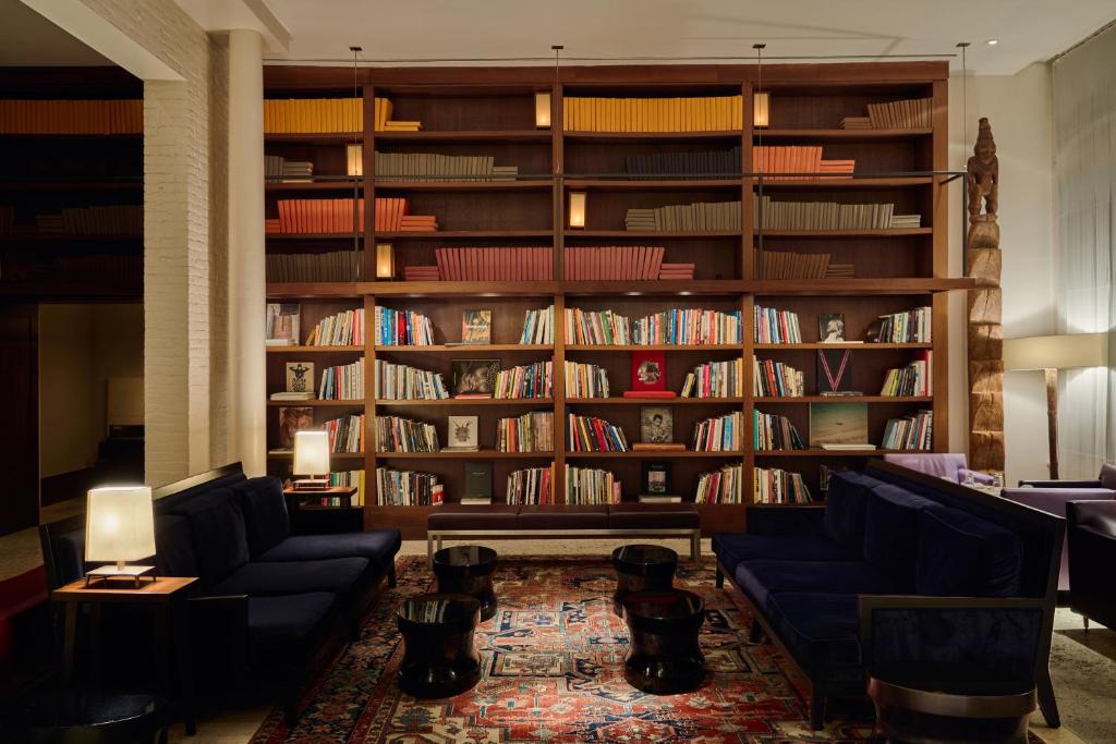 纽约美世酒店的图书馆,配有两张蓝色的沙发和书架