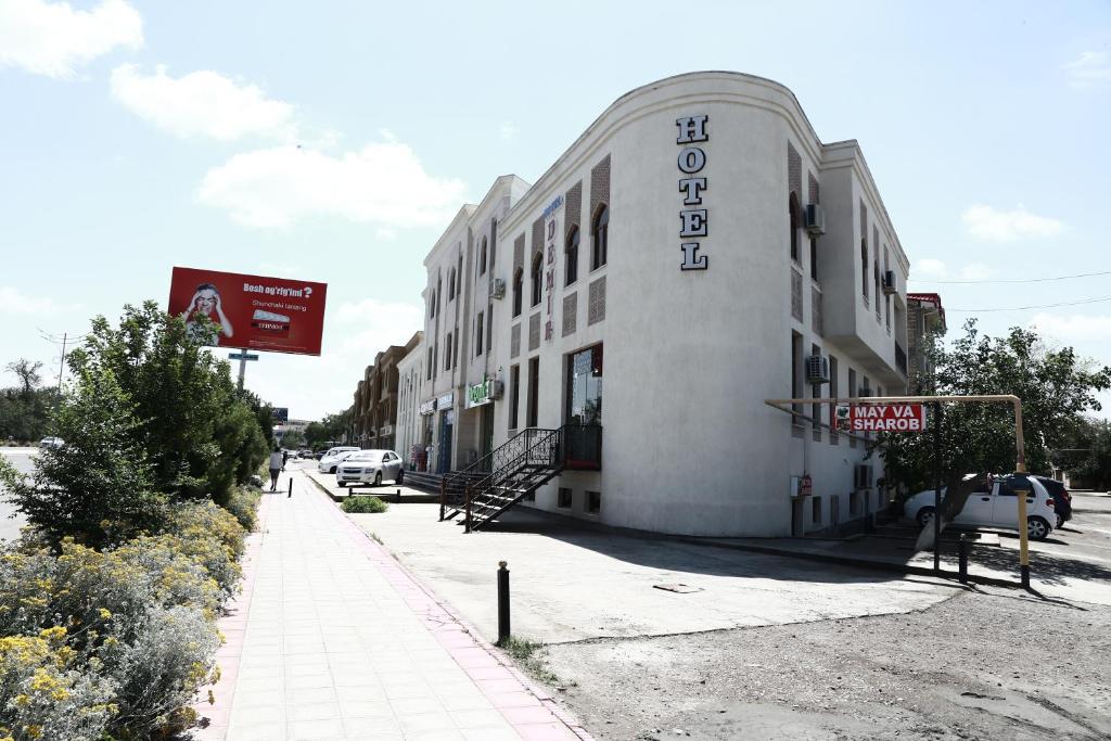 布哈拉Demir Hotel Bukhara的白色的建筑,旁边标有标志
