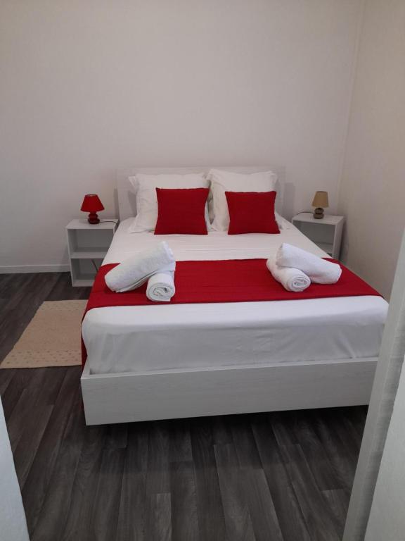 波尔兰特Chez Lucile et Gilbert的卧室配有带红色枕头的大型白色床