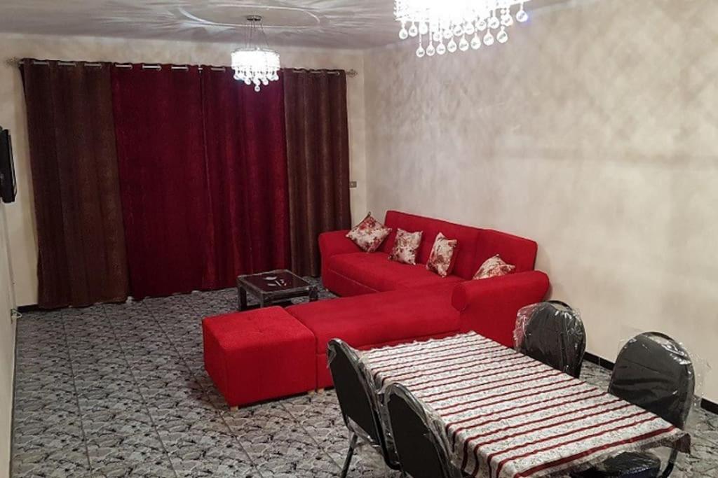 开罗Fantastic Apartment Near Cairo Airport的客厅配有红色的沙发和桌子